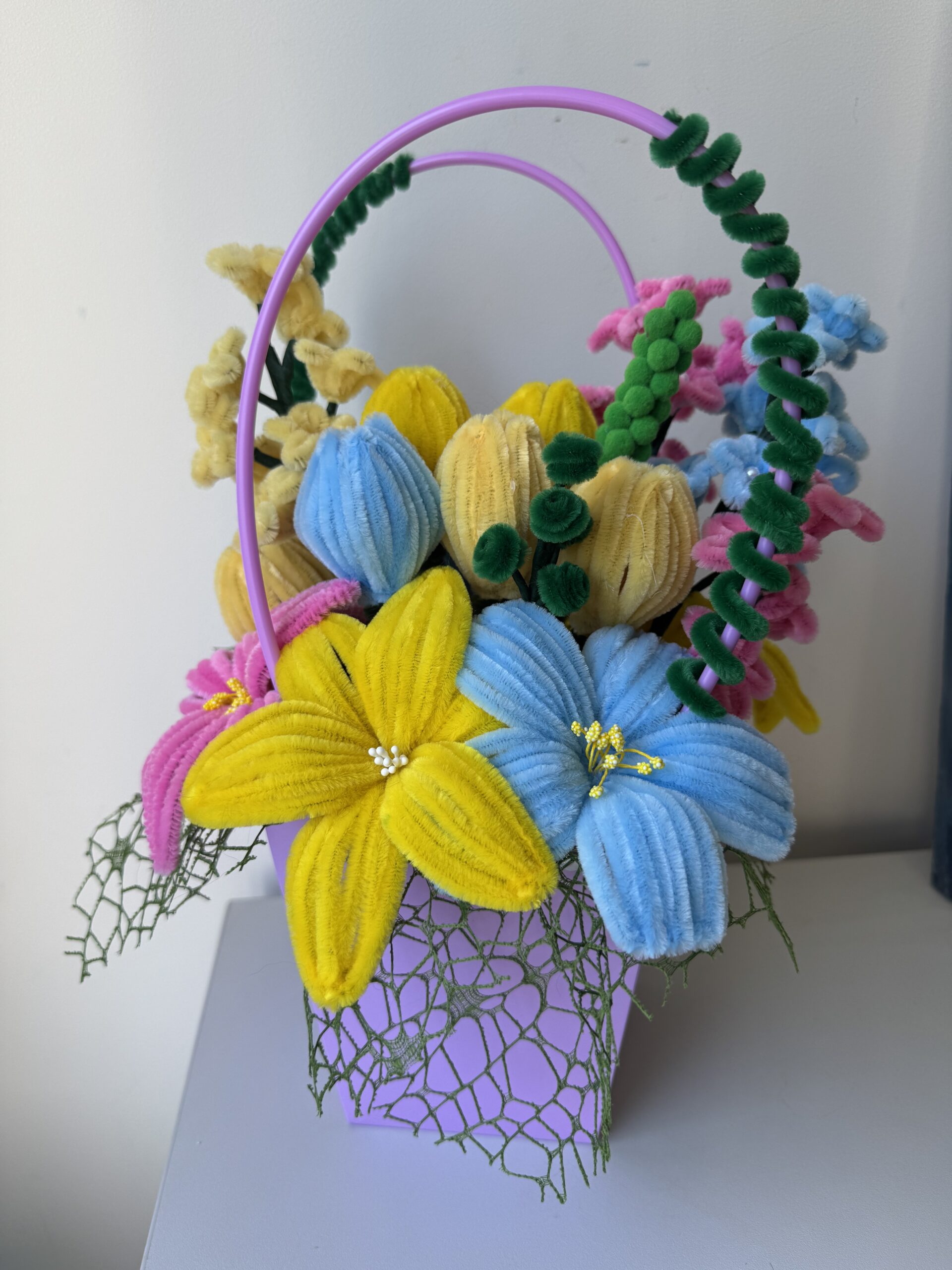 Šenilo gėlių puokštė su alyviniu krepšeliu (ryški)